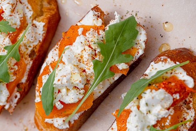 Grilled ciabatta bruschetta with baked pumpkin, feta arugula\
and spices. healthy fall baked pumpkin snack