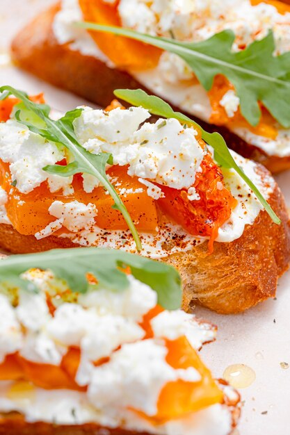 Grilled ciabatta bruschetta with baked pumpkin, feta arugula\
and spices. healthy fall baked pumpkin snack