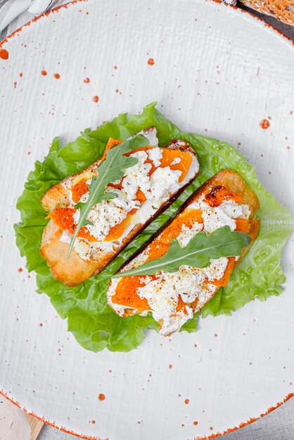 Grilled ciabatta bruschetta with baked pumpkin, feta arugula and spices. healthy fall baked pumpkin snack