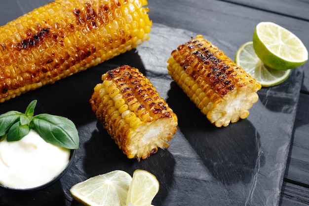 Grilled corn on the cob with butter and salt on the grill plate closeup top view