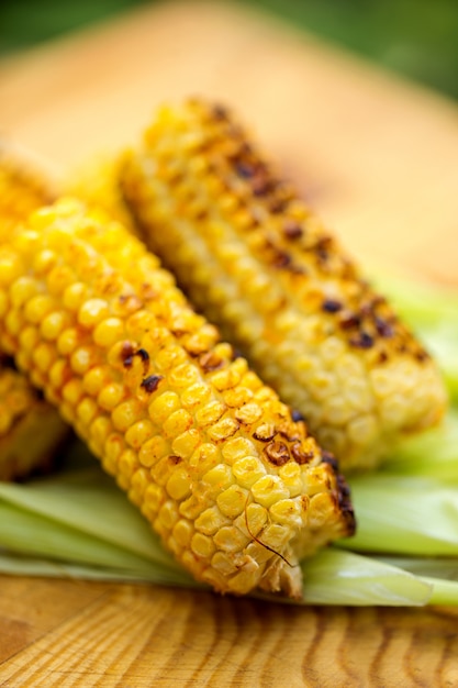 Photo grilled corn cobs on rustic wood