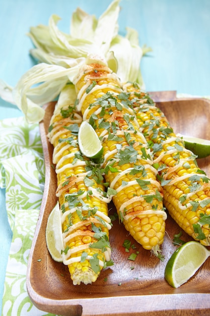 Grilled corn with chili peppers, white sauce and herbs