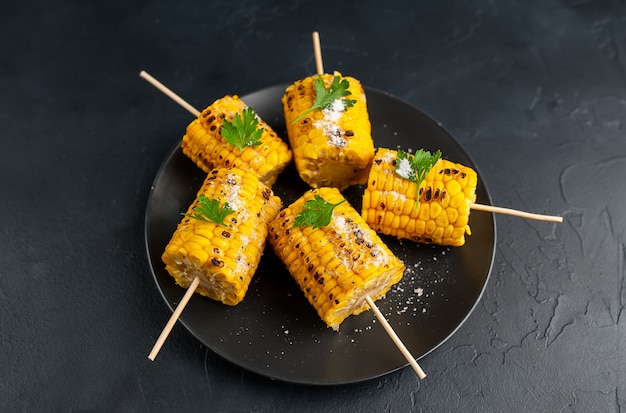 Grilled corn with greens and salt on the background of concrete, snack or dinner, breakfast