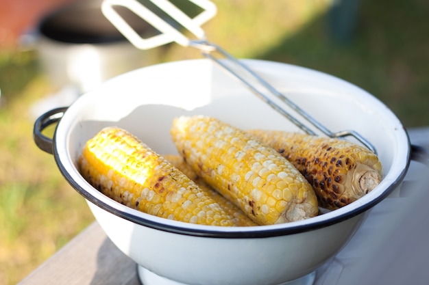 Photo grilled corns bbq in a white bowl, barbeque party