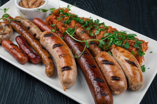 Grilled different sausage with the addition of herbs and horseradish sauce on the plate grilling foo