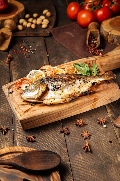 Grilled dorado fish on a wooden board