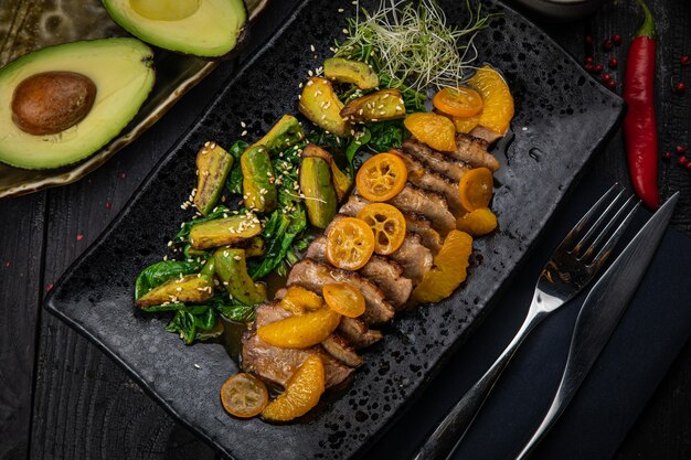 Grilled duck fillet with green salad, avocado and baked kumquat