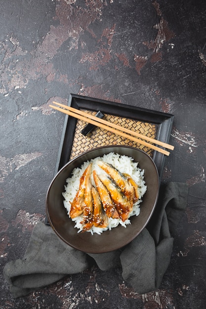 暗い背景にご飯と焼きウナギ