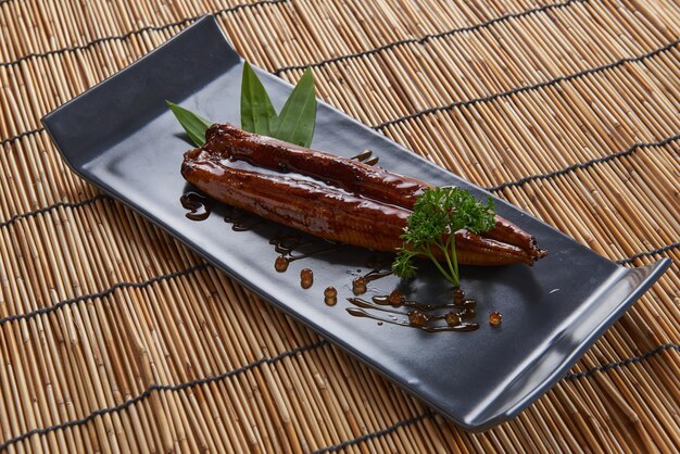 Photo grilled eel with sauce served on a black tile plate the best food of japan