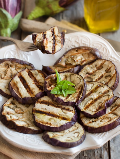 Grilled eggplants seasoned with olive oil on plate close up