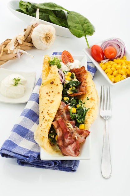 Grilled eggs with vegetables and herbs on wooden table