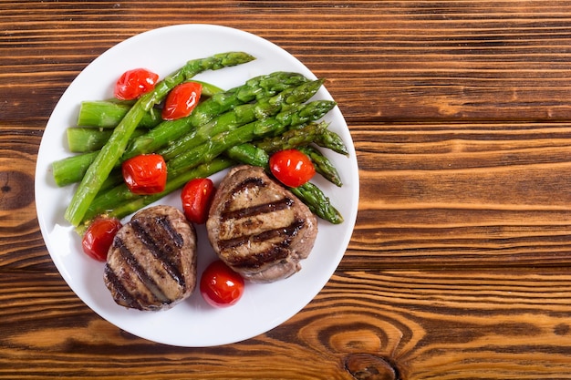 grilled filet mignon with asparagus and tomatoes beef sreak on rustic background