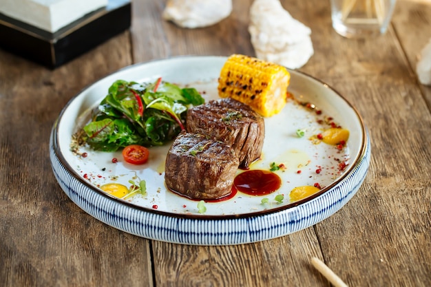 Grilled fillet mignon steaks with corn and salad