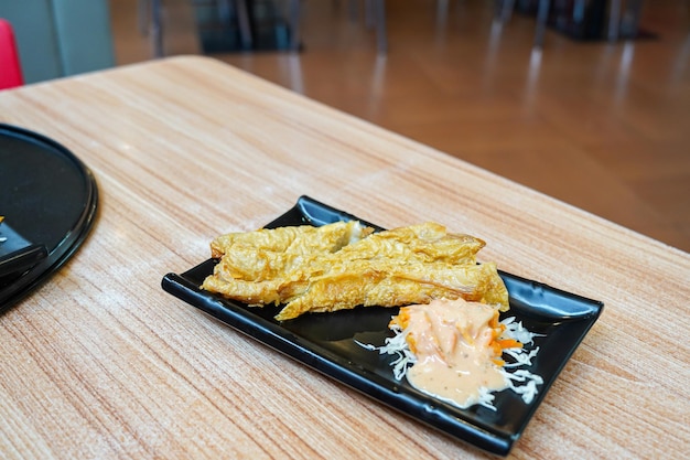 grilled fish cake ( otak otak ) Fried fish cakes on a plate, served with vegetable salad