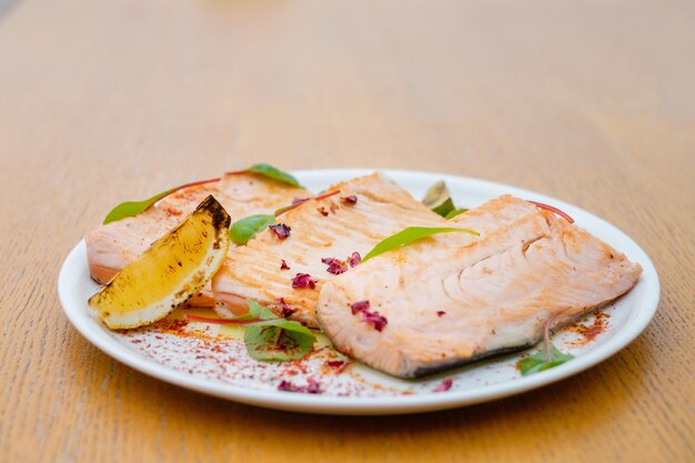 Pesce alla griglia guarnito con limone e basilico vista dall'alto menu per banchetti catering decorato con diversi snack e stuzzichini con panino