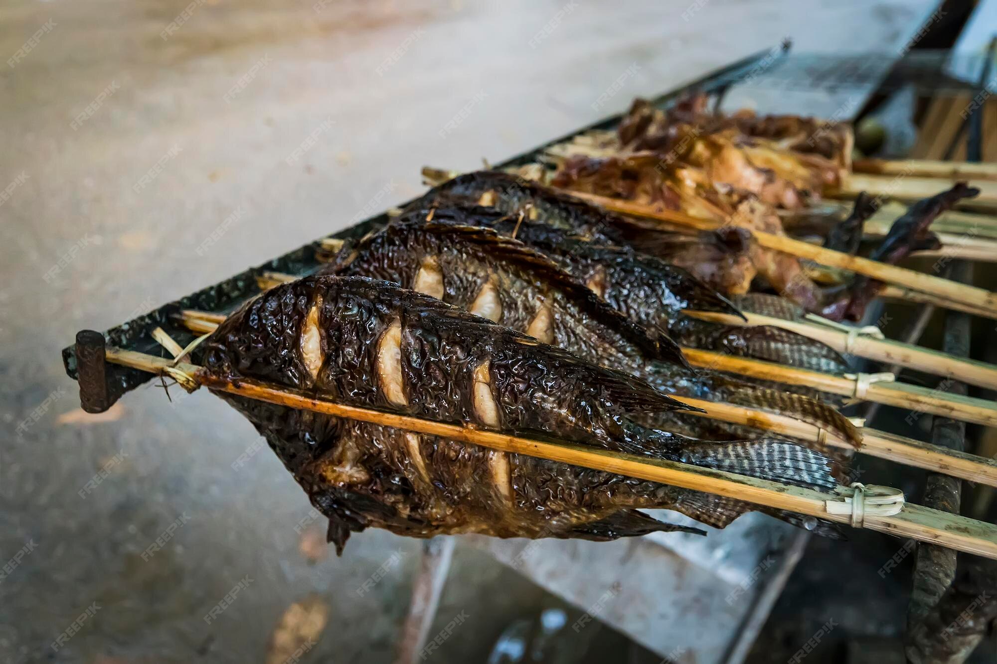 Premium Photo | Grilled fish is on the counter of a street shop street