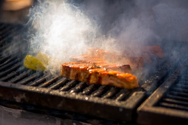 焼き魚のステーキ サーモンの切り身を直火で揚げる 火と煙が魚の切り身に転がる