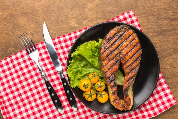 Photo grilled fish with lettuce flat lay