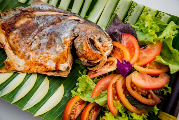 Grilled fish with vegetables, palm leaf. restaurant