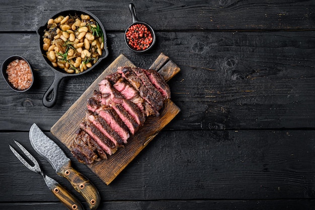 Grilled or fried and sliced marbled meat steak rib eye set on wooden serving board