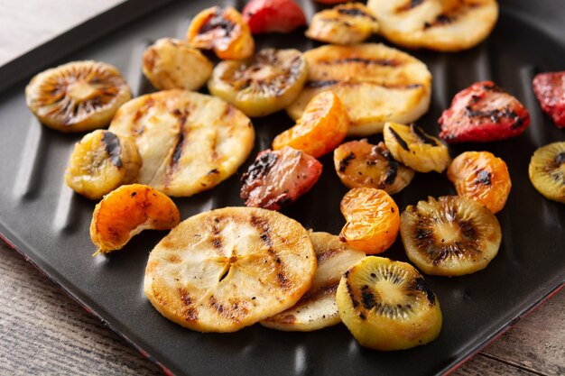 Grilled fruit in the iron pan on wooden table