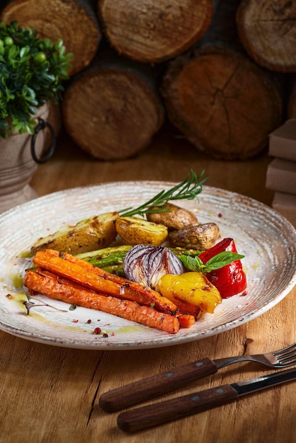 Grilled green vegetables bell pepper onion potatoes markov and rosemary on a plate On a wooden table closeup