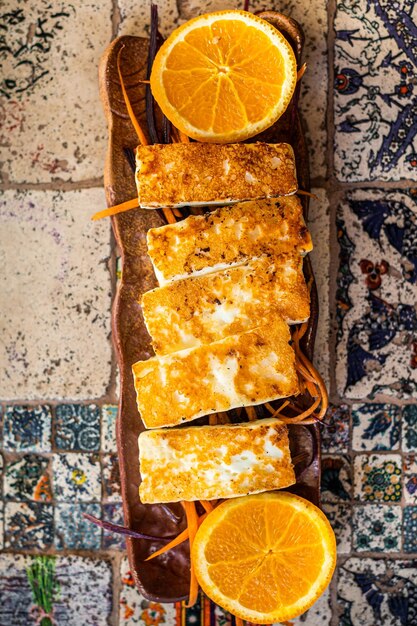 Grilled Halloumi Cheese on a plate with herbs Top view