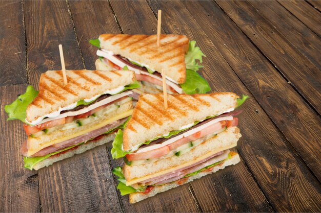 Grilled halves of sandwiches on wooden table