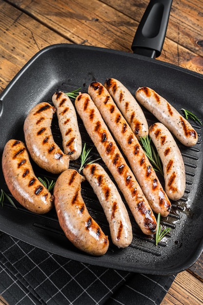 Grilled homemade sausages with Beef pork lamb and chicken mince meat in a grill skillet Wooden background Top view
