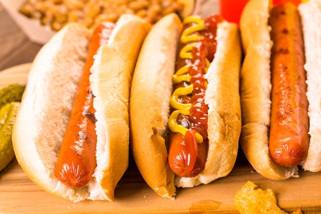 Grilled hot dogs on a white hot dog buns with mustard and ketchup.