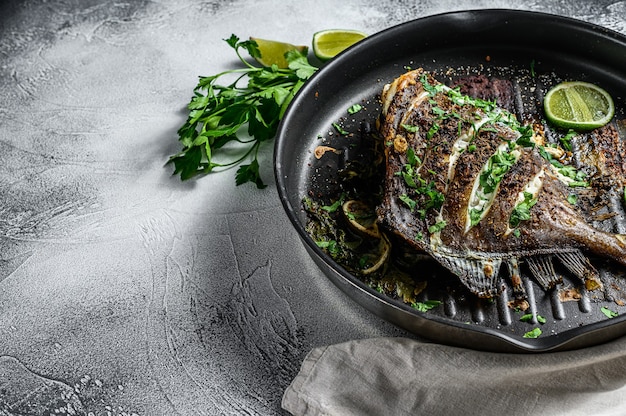 Grilled John Dory fish with lime and parsley in a pan