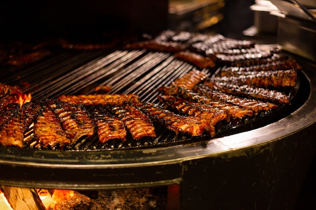 Grilled juicy meat on a large wood-fired oven
