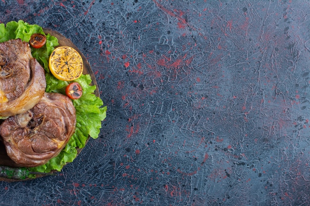 Bistecca succosa alla griglia con verdure arrosto su tavola di legno.