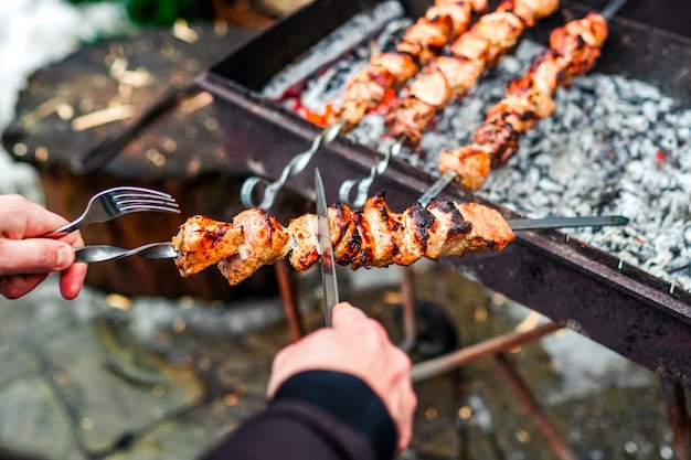 Grilled kebab cooking on metal skewer. Roasted meat cooked at barbecue