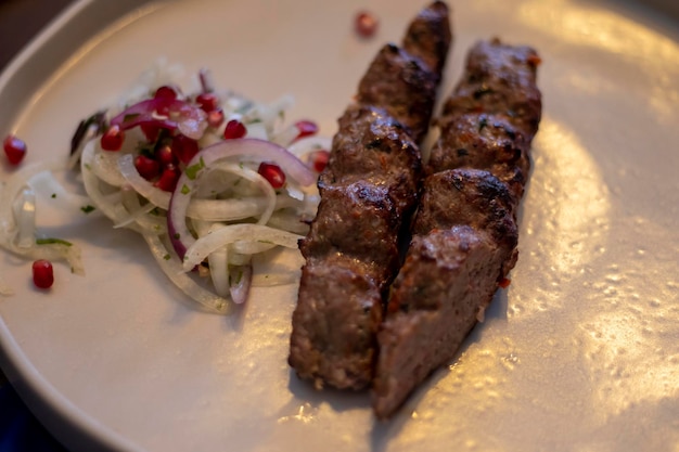 Grilled kebab with spices and grilled vegetables sauces and fresh onions with pomegranate