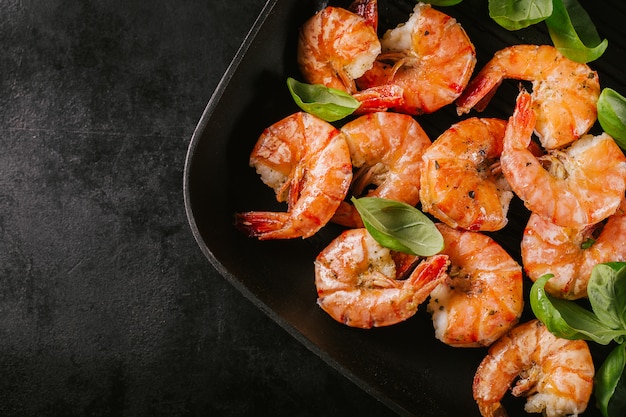 Photo grilled king prawns on pan on dark table