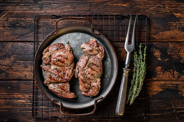 Grilled Lamb chop leg steaks mutton meat with herbs Wooden background Top view