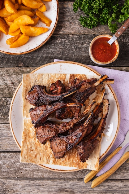 Grilled lamb chops on a plate. Top view