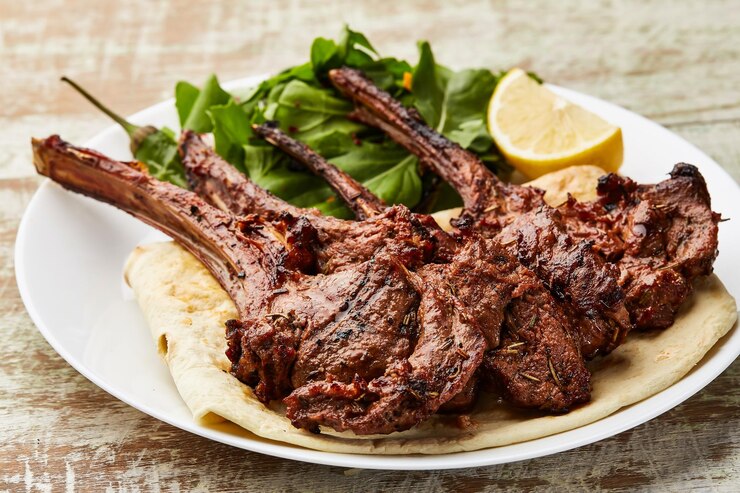 Photo grilled lamb chops with lemon slice ad salad served in dish isolated on table top view of arabic food