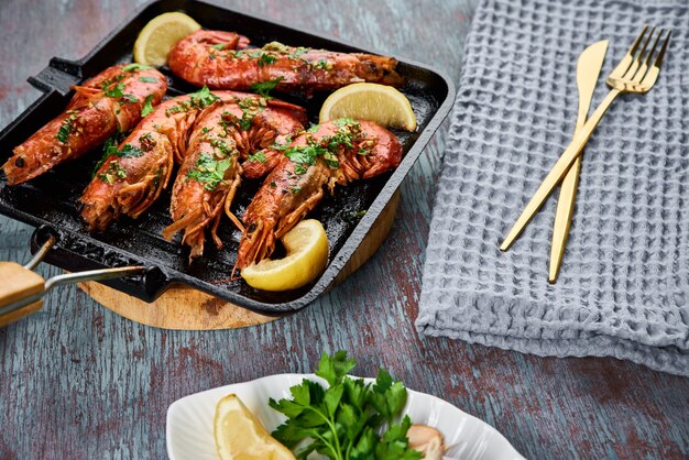 Grilled large queen shrimps with lemon and spices on grill pan