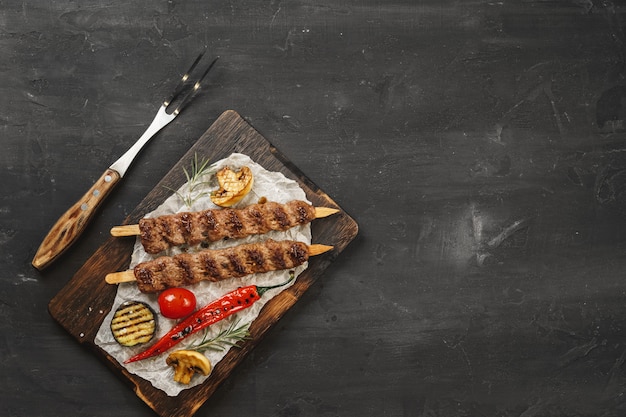 Photo grilled lula kebab on skewers served on wooden board
