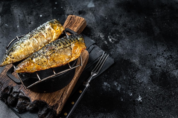 Filetto di pesce sgombro alla griglia su una griglia sfondo nero vista dall'alto spazio di copia