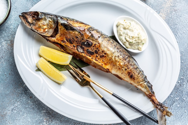 Grilled mackerel fish with lemon and sauce. banner, menu recipe place for text, top view