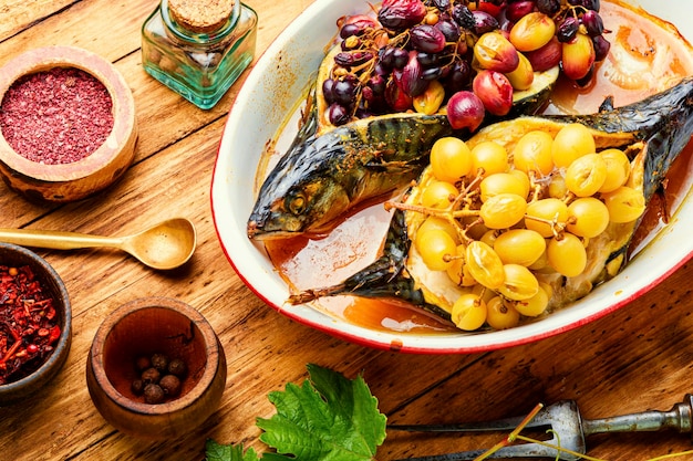 Grilled mackerel or scomber in berry sauce on wooden table