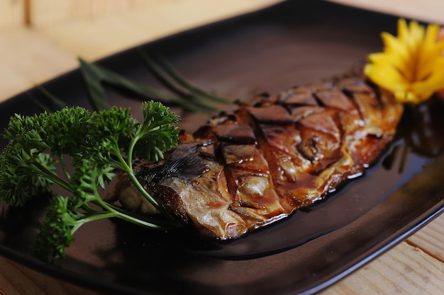grilled mackerel with salt on a plate
