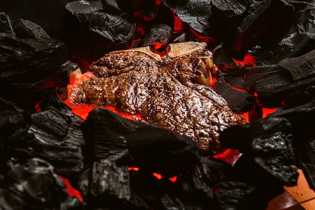 Grilled marbled beef steak with coals and smoke