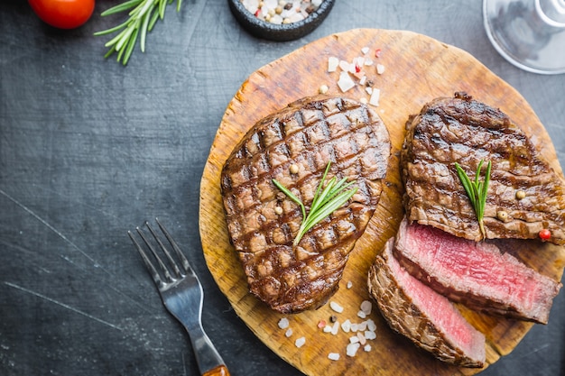 霜降り肉のグリルフィレミニョンと調味料。まな板の上にジューシーなビーフステーキ、上面図。