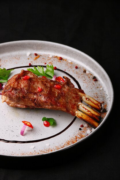 Grilled meat on the bone ribs closeup on ceramic plate.