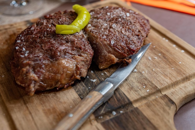 Grilled meat fillet on a board with a knife