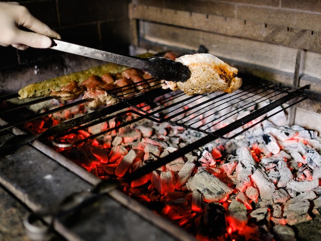 Grilled meat preparation process. Chef craftsmanship of barbecued charred steak and shashlik